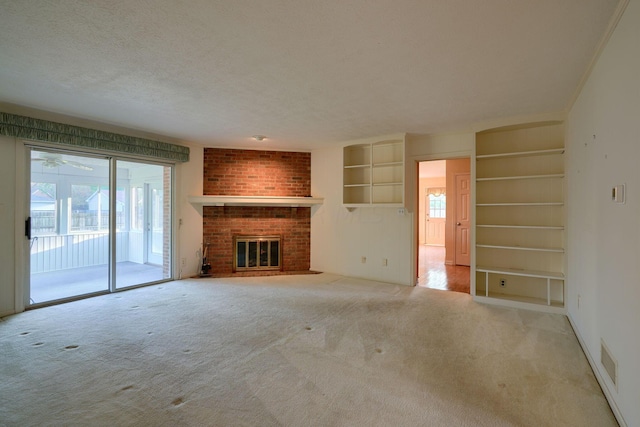 unfurnished living room featuring a fireplace, a textured ceiling, and light colored carpet