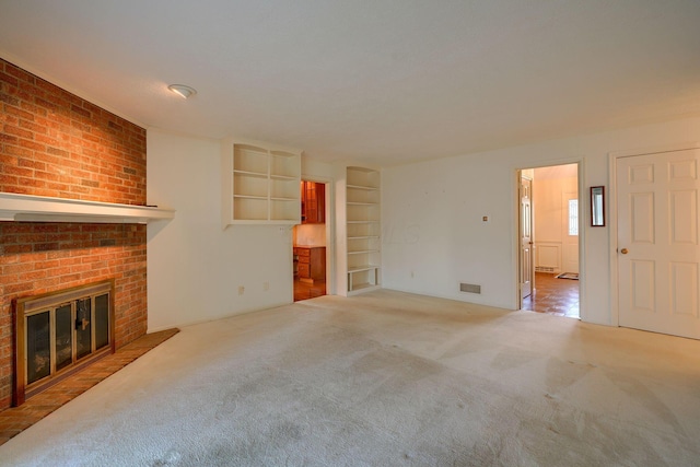 unfurnished living room with a fireplace, carpet, and built in features