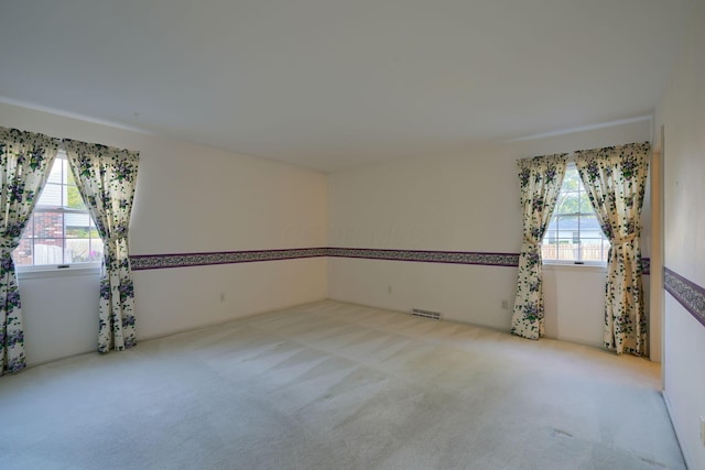 carpeted spare room featuring plenty of natural light