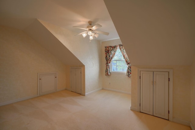 additional living space with ceiling fan, lofted ceiling, and light carpet