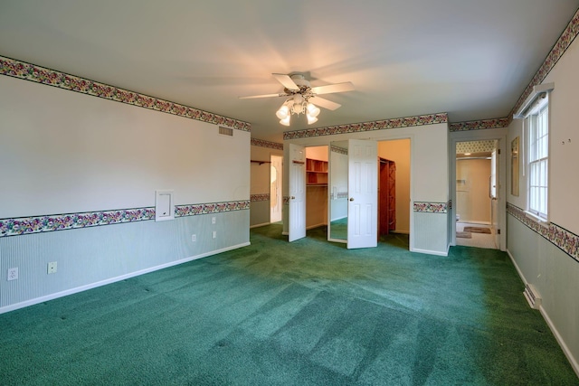 spare room featuring dark colored carpet and ceiling fan