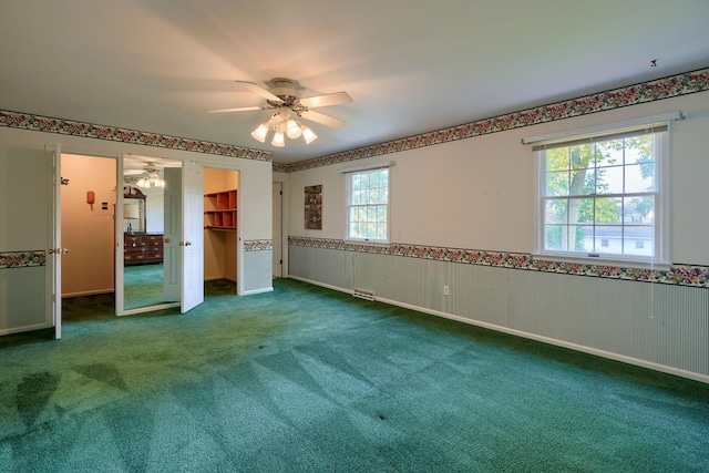 unfurnished bedroom featuring carpet flooring, ceiling fan, and multiple windows