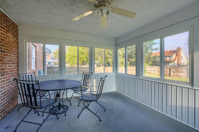 sunroom featuring ceiling fan and plenty of natural light