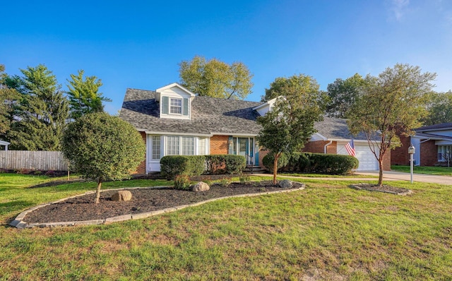 new england style home featuring a front yard and a garage