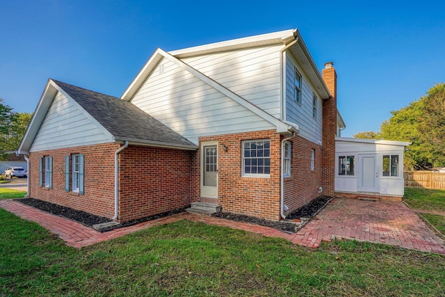 back of house with a yard and a patio