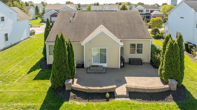 rear view of house with a lawn and a patio area