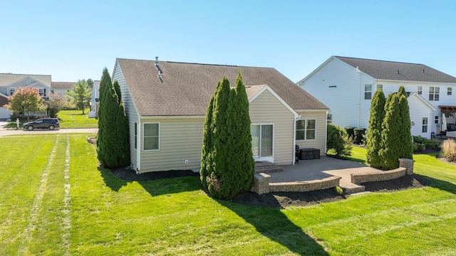 rear view of house with a lawn and a patio