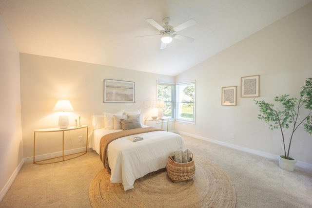 bedroom with ceiling fan, light colored carpet, and vaulted ceiling