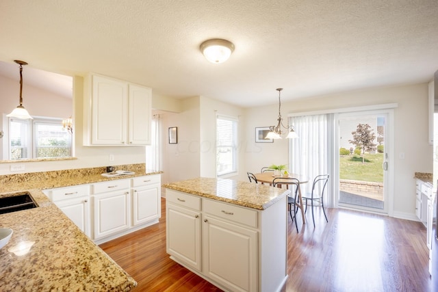 kitchen with plenty of natural light, a kitchen island, and white cabinetry