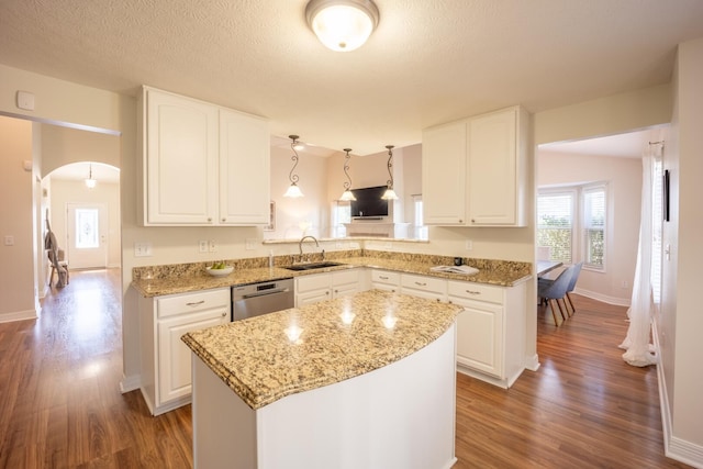 kitchen with dishwasher, pendant lighting, white cabinetry, and a kitchen island