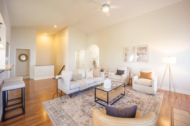 living room with hardwood / wood-style flooring, high vaulted ceiling, and ceiling fan