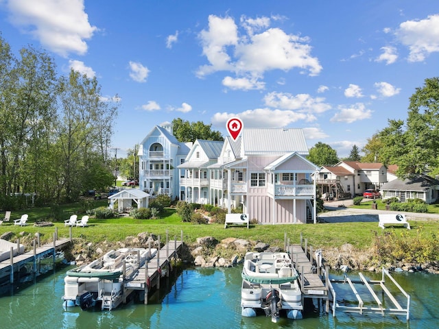 dock area featuring a yard, a water view, and a balcony