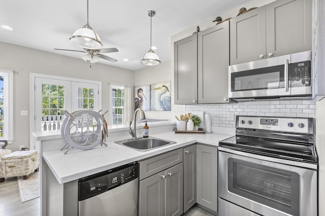 kitchen with light wood-type flooring, stainless steel appliances, gray cabinetry, and sink