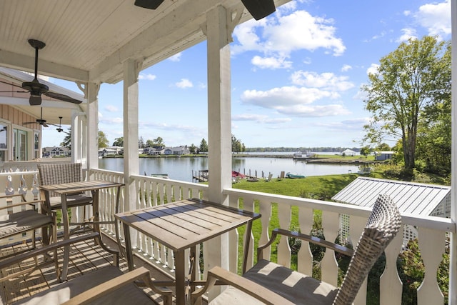 balcony with ceiling fan and a water view