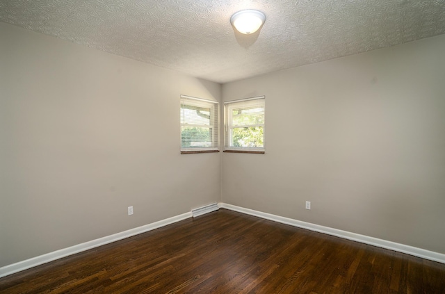 unfurnished room with a textured ceiling and dark hardwood / wood-style flooring