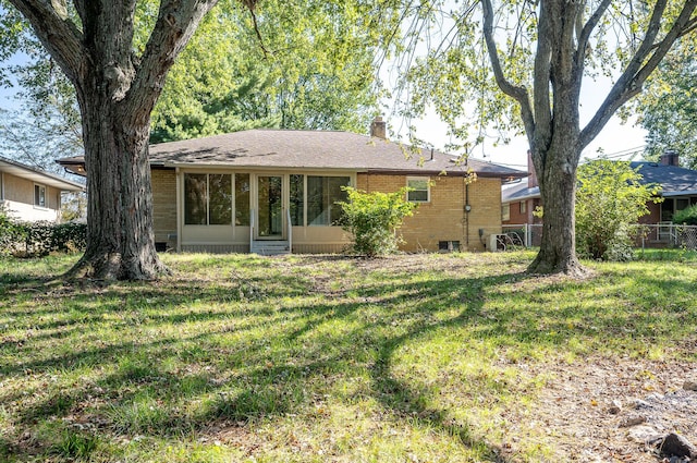 rear view of property featuring a lawn