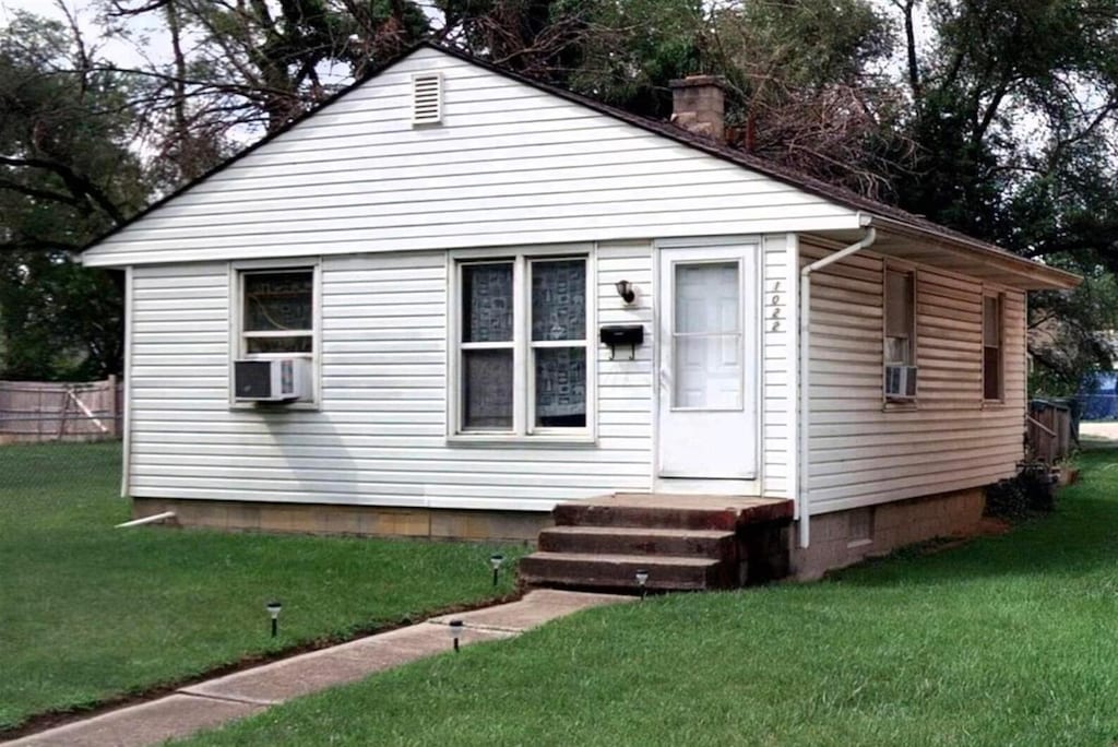 view of front of house with a front lawn and cooling unit