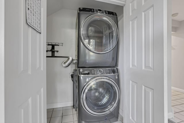 laundry room with light tile patterned flooring and stacked washer / drying machine