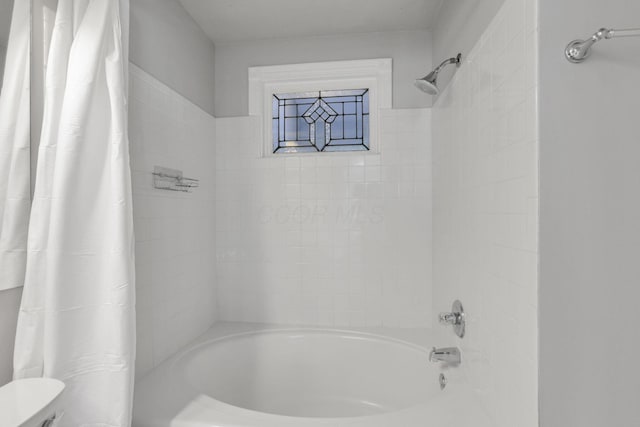 bathroom with shower / bath combination with curtain and toilet