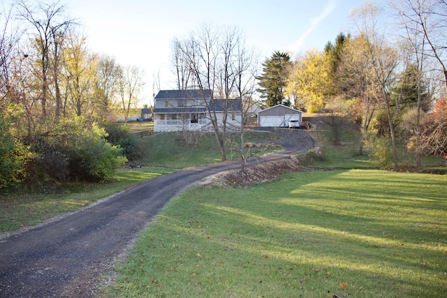 view of front of house featuring an outdoor structure, a front yard, and a garage