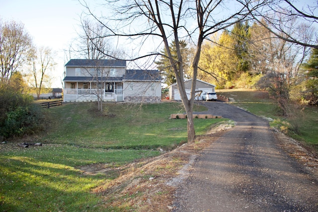 view of front of house with an outdoor structure, a front yard, and a garage