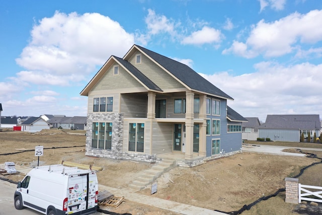 view of front facade with stone siding and fence