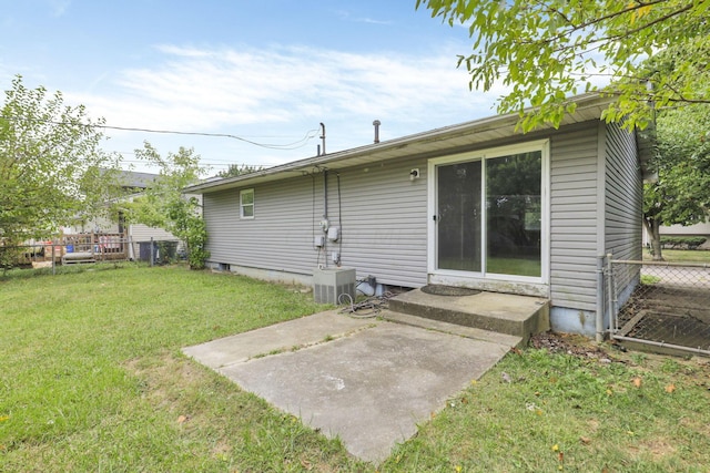 back of property with a lawn and a patio area