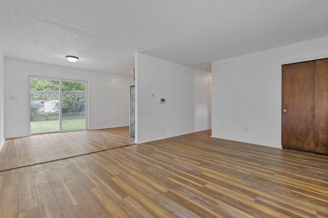 unfurnished living room featuring hardwood / wood-style floors and a textured ceiling