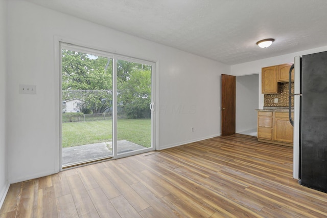 unfurnished living room with wood-type flooring and a textured ceiling