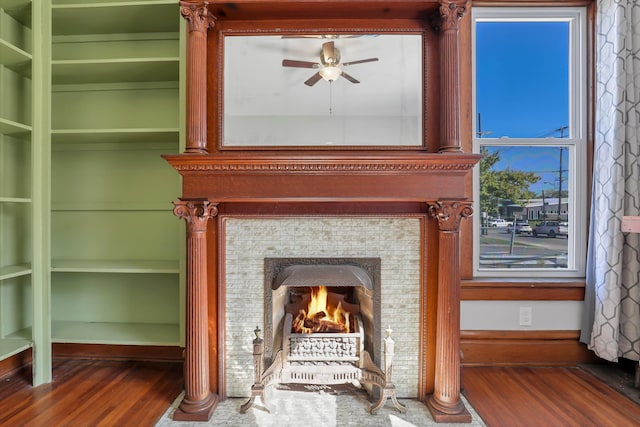 details featuring a tile fireplace, ceiling fan, and hardwood / wood-style flooring