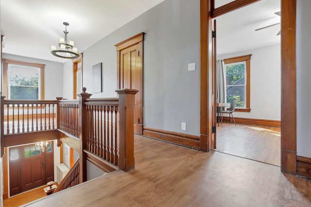 corridor with light hardwood / wood-style floors and a chandelier