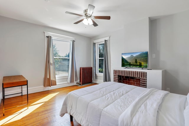 bedroom featuring ceiling fan, light wood-type flooring, and radiator