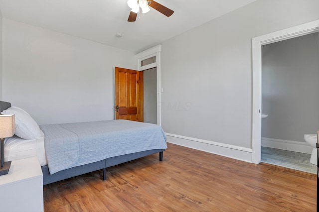 bedroom with ceiling fan, wood-type flooring, and ensuite bathroom