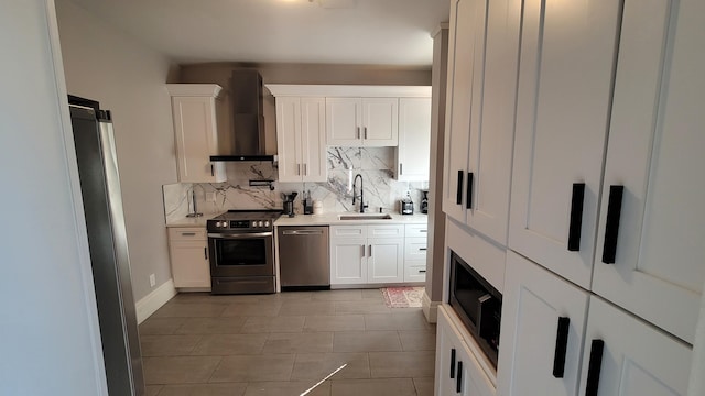 kitchen with wall chimney exhaust hood, sink, white cabinetry, and stainless steel appliances