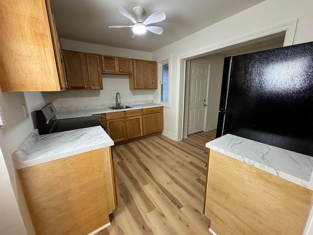 kitchen with ceiling fan, sink, light hardwood / wood-style floors, black refrigerator, and range