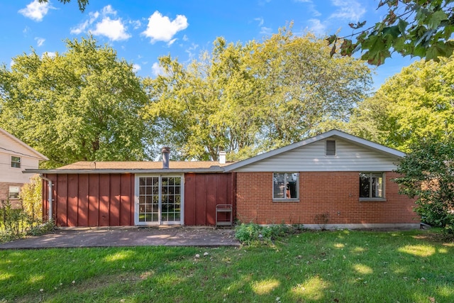 back of property featuring a yard