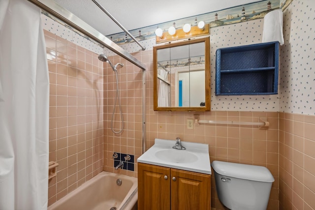 full bathroom featuring a textured ceiling, vanity, shower / tub combo with curtain, tile walls, and toilet