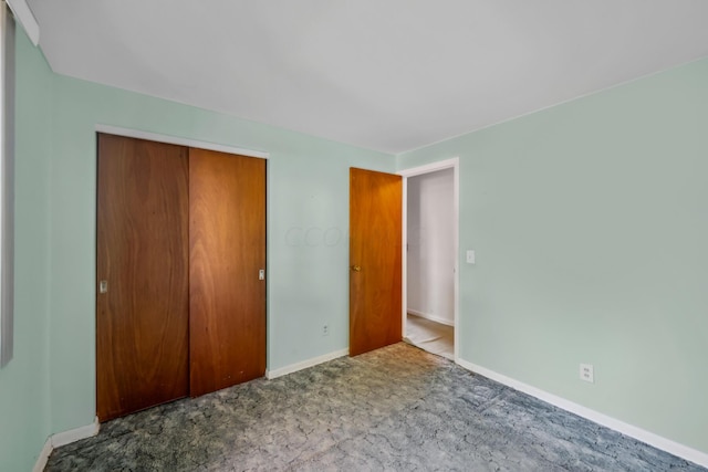 unfurnished bedroom featuring carpet flooring and a closet