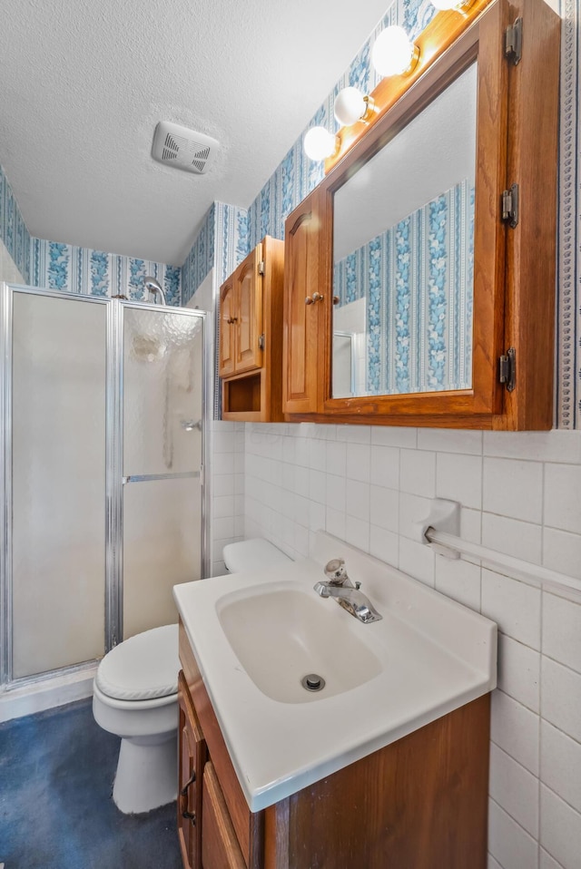 bathroom with vanity, an enclosed shower, tile walls, and toilet