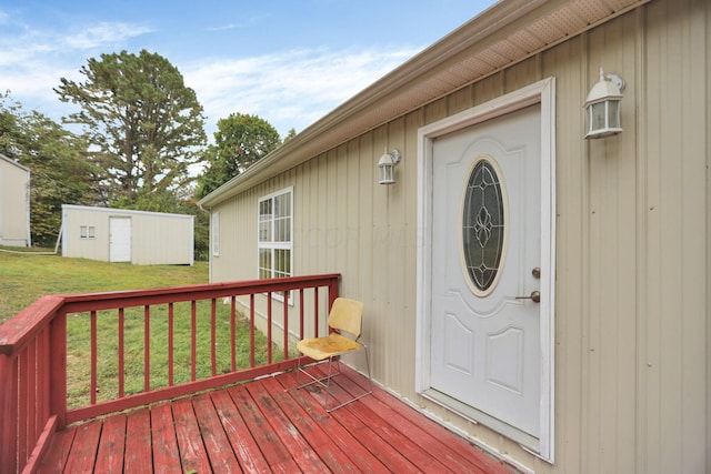 view of exterior entry with a lawn and a wooden deck