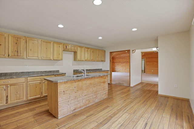 kitchen featuring light brown cabinets, sink, a center island with sink, and light hardwood / wood-style flooring