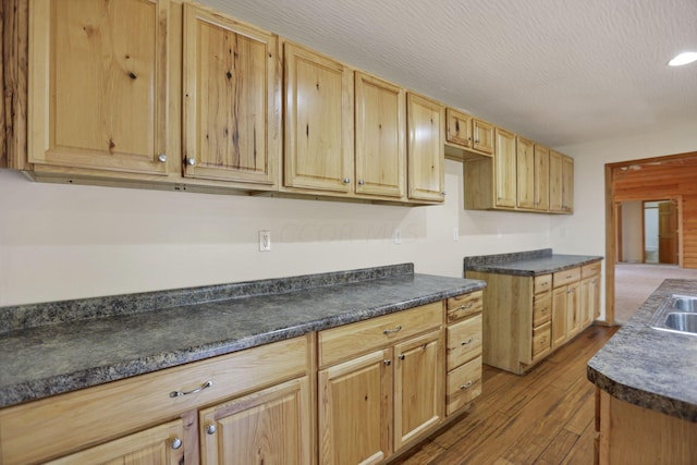 kitchen featuring a textured ceiling, light hardwood / wood-style floors, sink, and light brown cabinetry