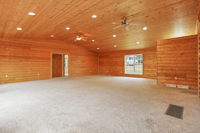 carpeted spare room featuring vaulted ceiling, ceiling fan, wood walls, and wood ceiling