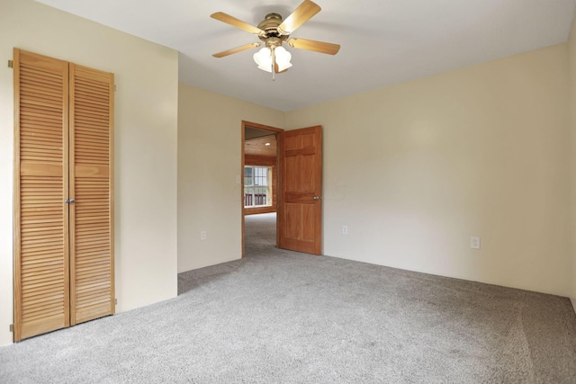 unfurnished bedroom featuring carpet flooring, ceiling fan, and a closet