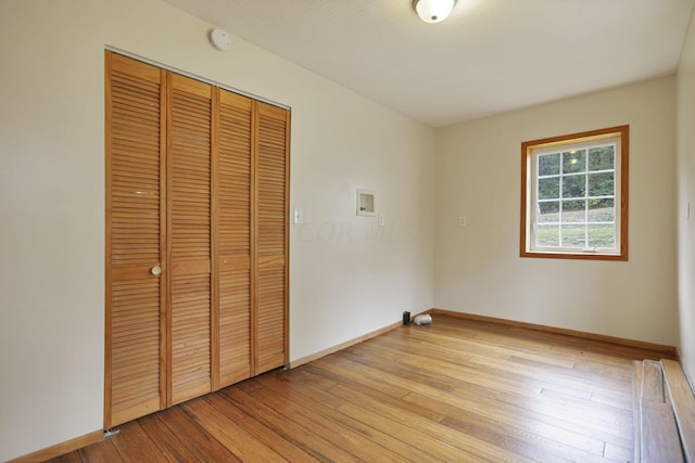 unfurnished bedroom featuring light hardwood / wood-style flooring and a closet