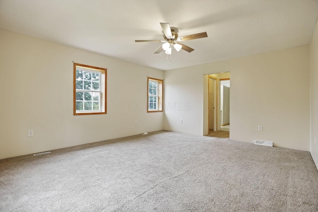 carpeted empty room featuring ceiling fan