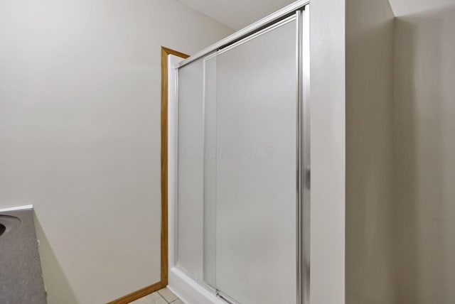 bathroom featuring tile patterned floors and a shower with door