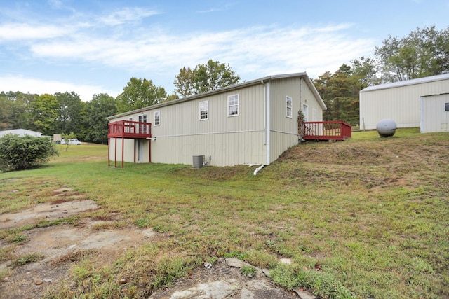 view of property exterior featuring cooling unit, a deck, and a yard