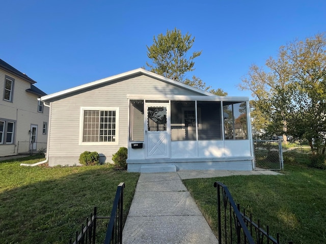 view of front of home featuring a sunroom and a front lawn