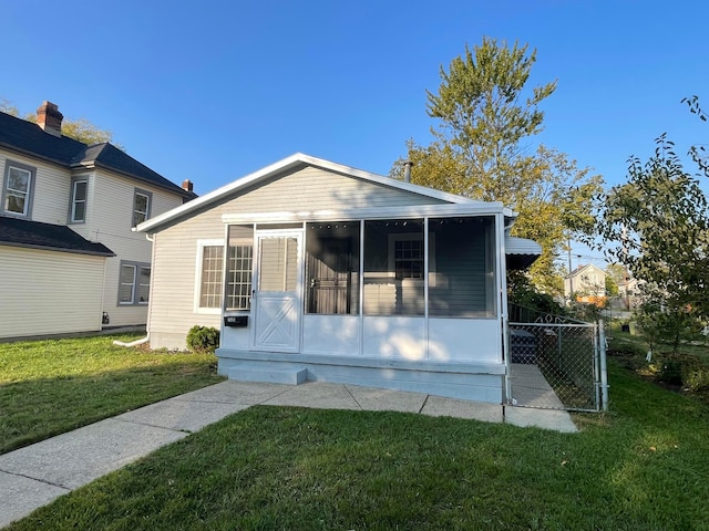 view of front of home featuring a front yard and a sunroom